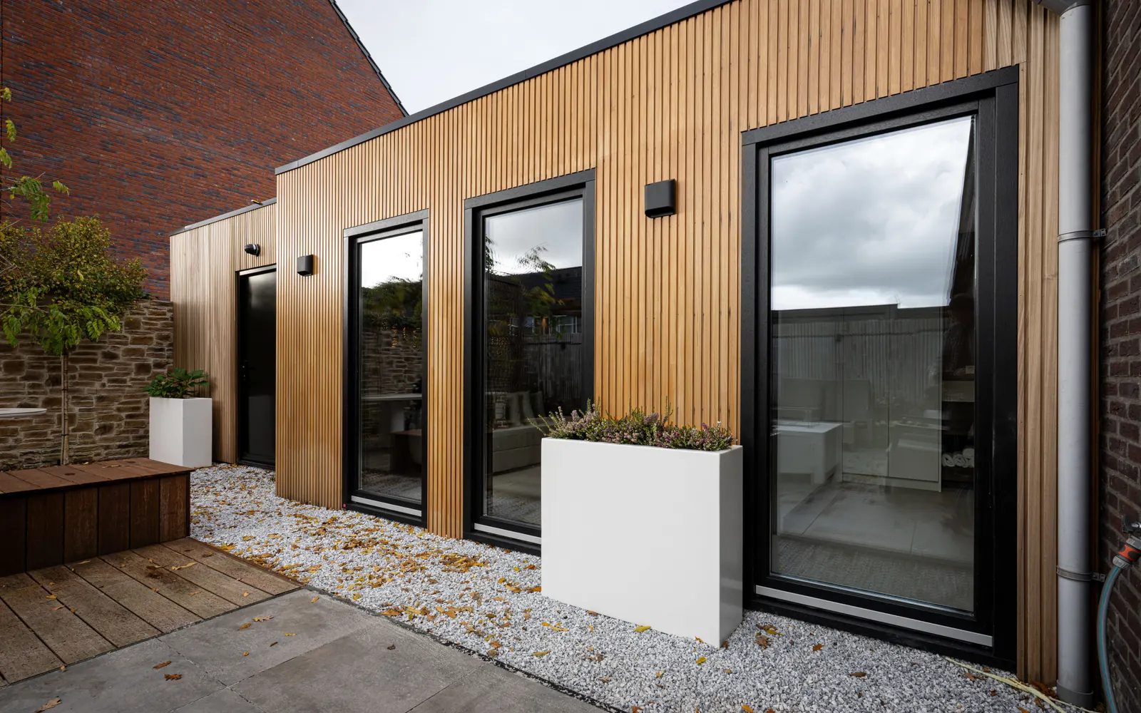 Houten woninguitbreiding met hoge ramen en aansluiting op de tuin